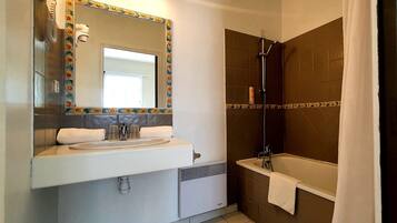Een badkamer met wastafel, spiegel en douche.