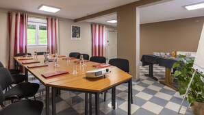 A conference room with a long table, chairs, a projector, and a buffet table with food and drinks. - The Originals City, Hotel Paray-Le-Monial (Paray-le-Monial)