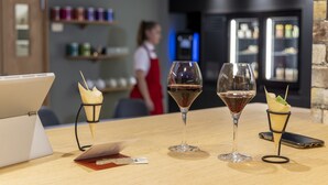 A laptop, two wine glasses, and a smartphone on a wooden table with a menu and a card. - The Originals City, Hotel Paray-Le-Monial (Paray-le-Monial)