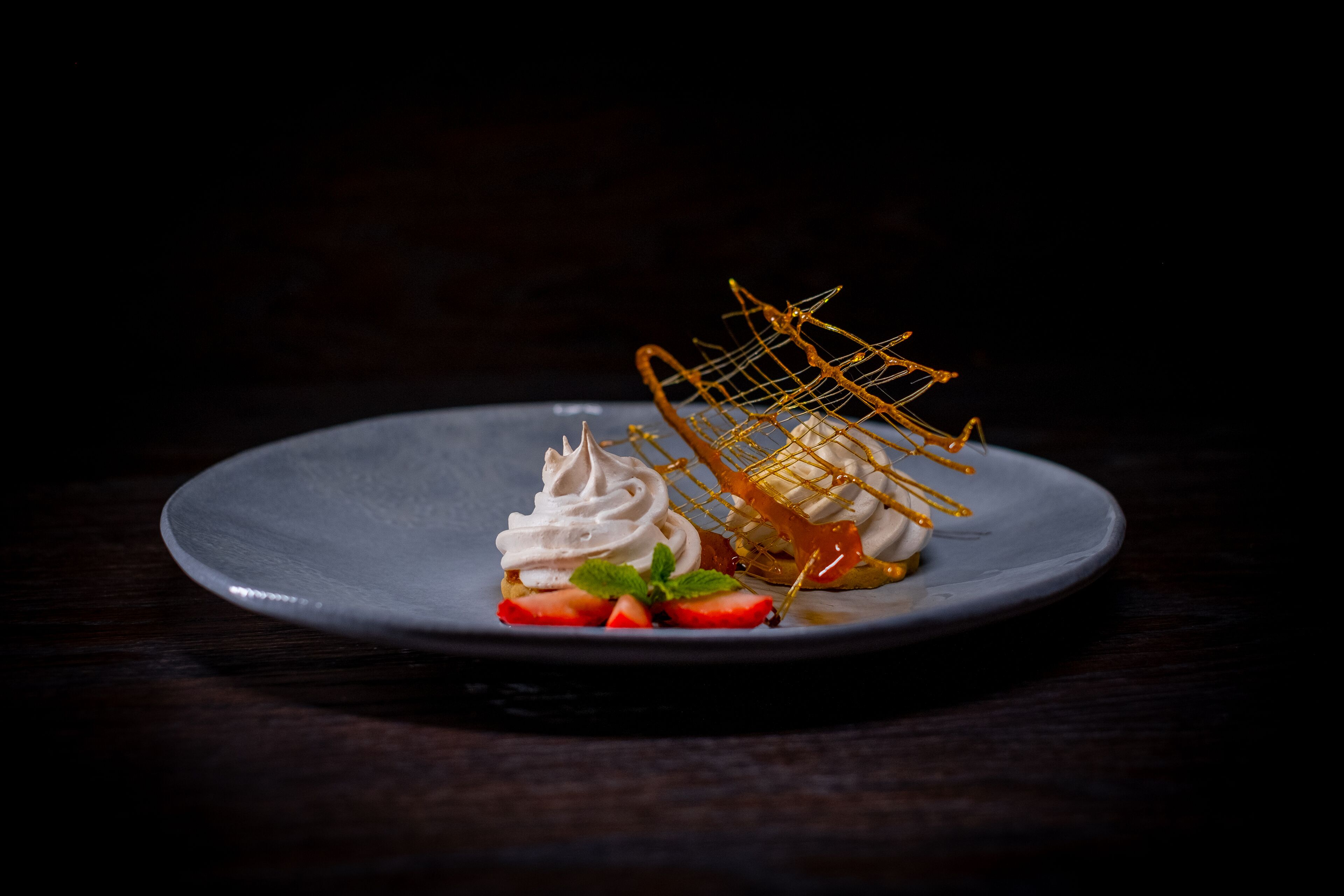 A dessert on a plate with a dark background.