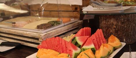 Un bufé con diversas frutas y un letrero que indica 'REGIOHOTEL'.