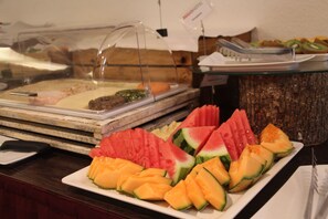 A buffet with various fruits and a sign indicating 'REGIOHOTEL'.