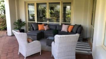 Relax on a comfortable sofa set in a serene outdoor space surrounded by a garden.