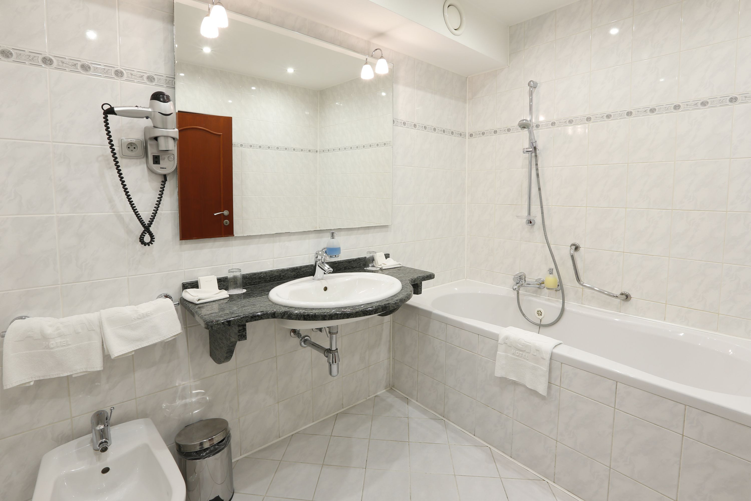 A modern bathroom with a sink, mirror, and shower.