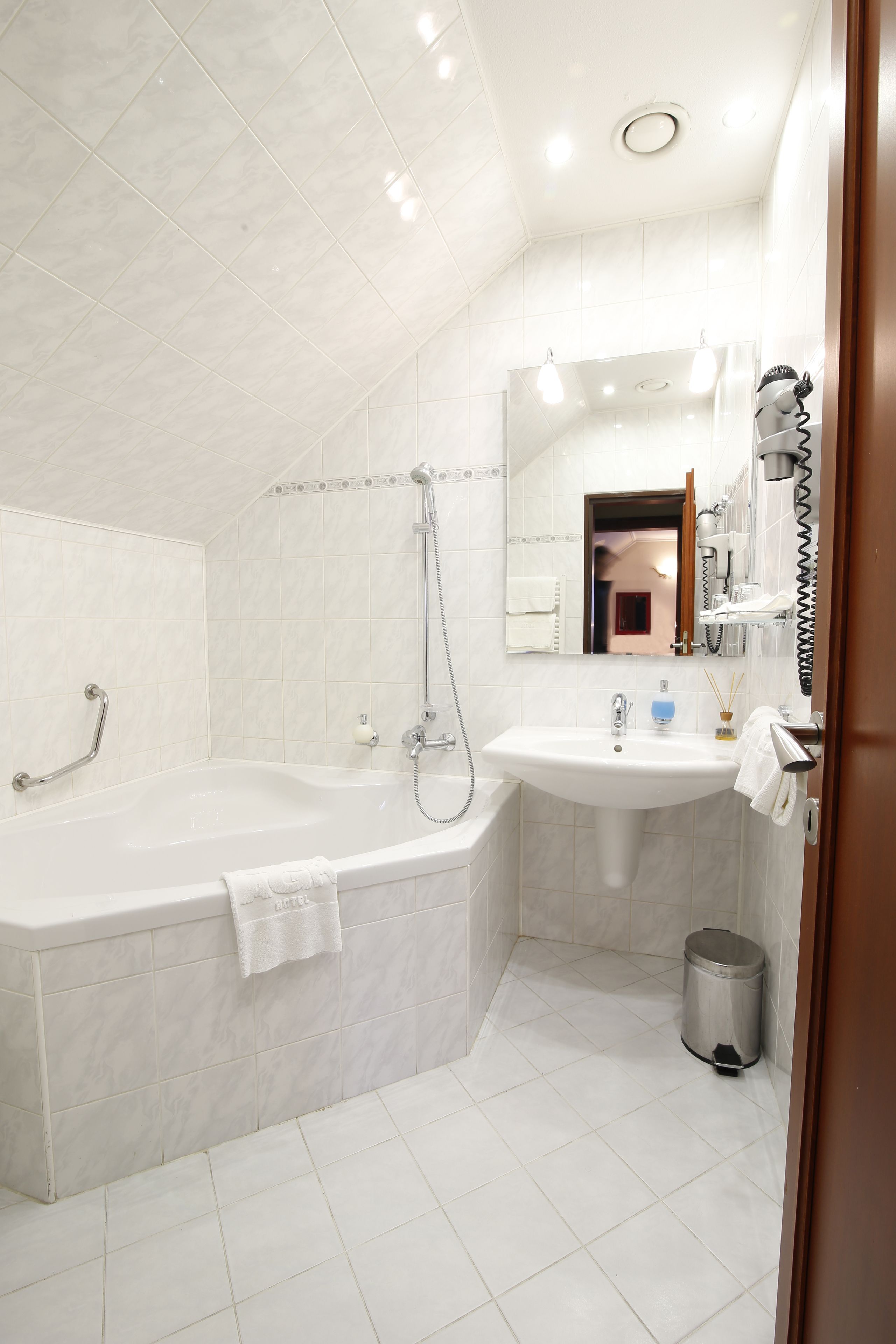 A modern bathroom with a bathtub, a sink, and a mirror.