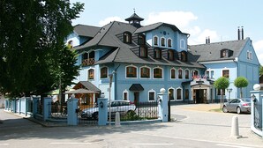 A large, multi-story hotel with a traditional architectural style, featuring a prominent entrance and a well-maintained exterior. - Agh Hotel (Roznov Pod Radhostem)