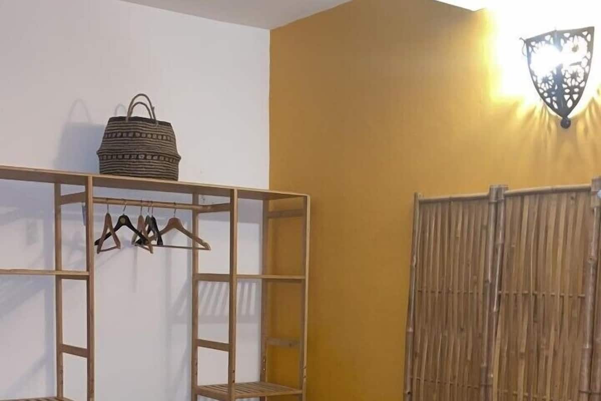 A room with a bunk bed, a hanging basket, and a wall-mounted light fixture.