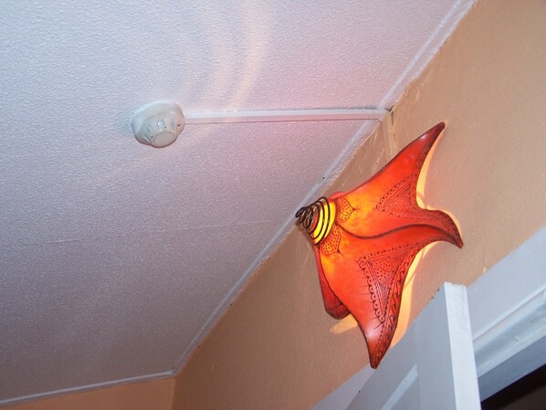 A ceiling with a white textured finish and a red decorative light fixture.