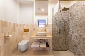 A modern bathroom with a toilet, sink, and shower.