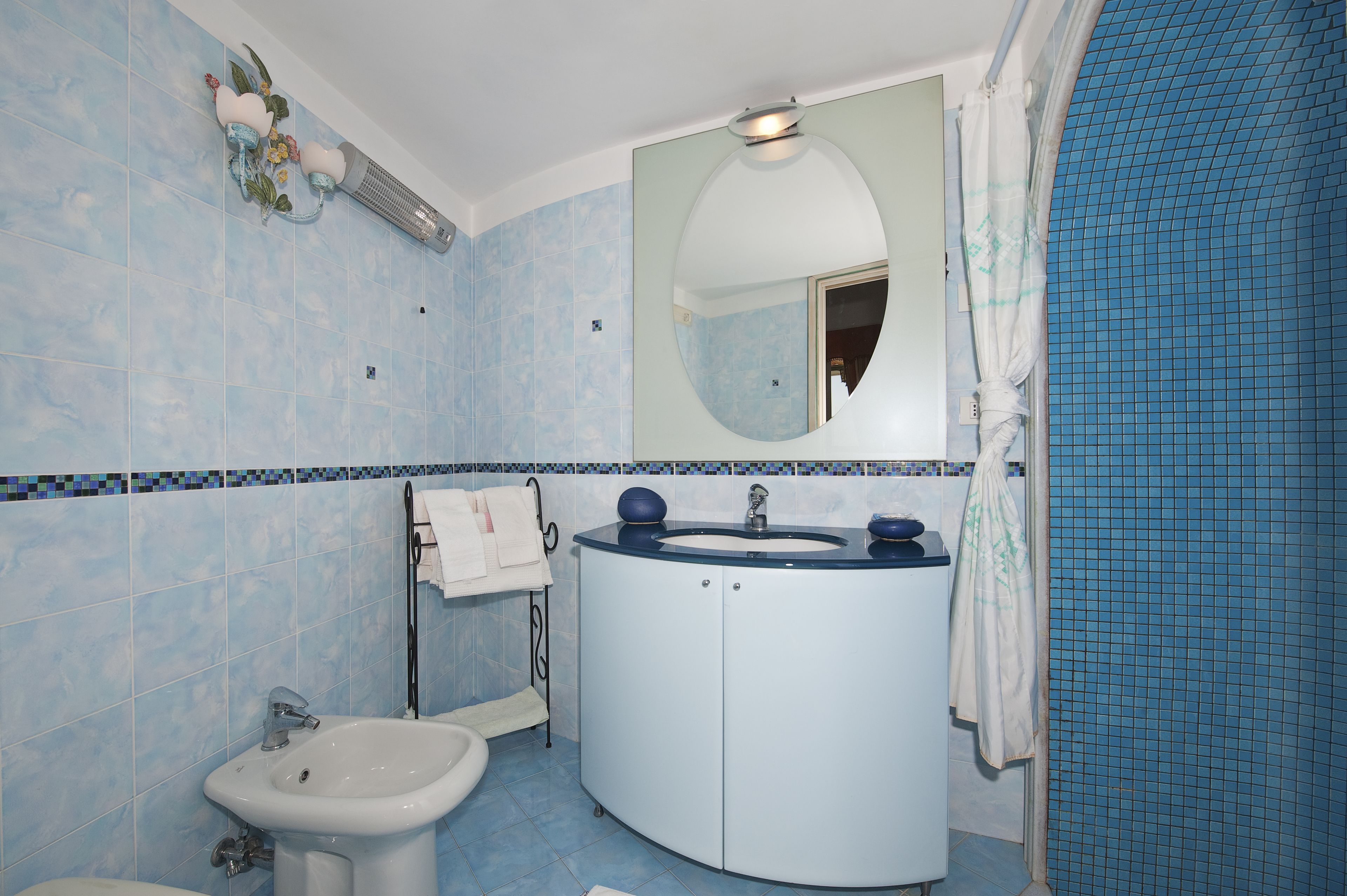 A bathroom with a sink, mirror, and toilet.