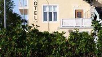 Un edificio de dos pisos con un letrero que dice "HOTEL" en el costado.