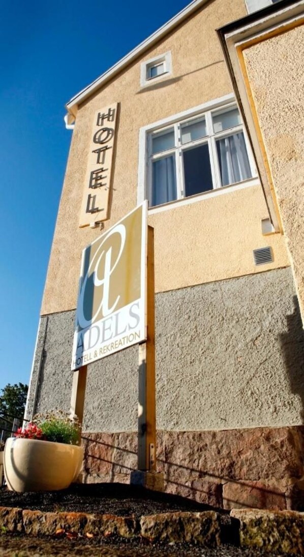 Un edificio de hotel con un cartel que indica 'HOTEL' y 'ADELS HOTEL & RECREATION'.