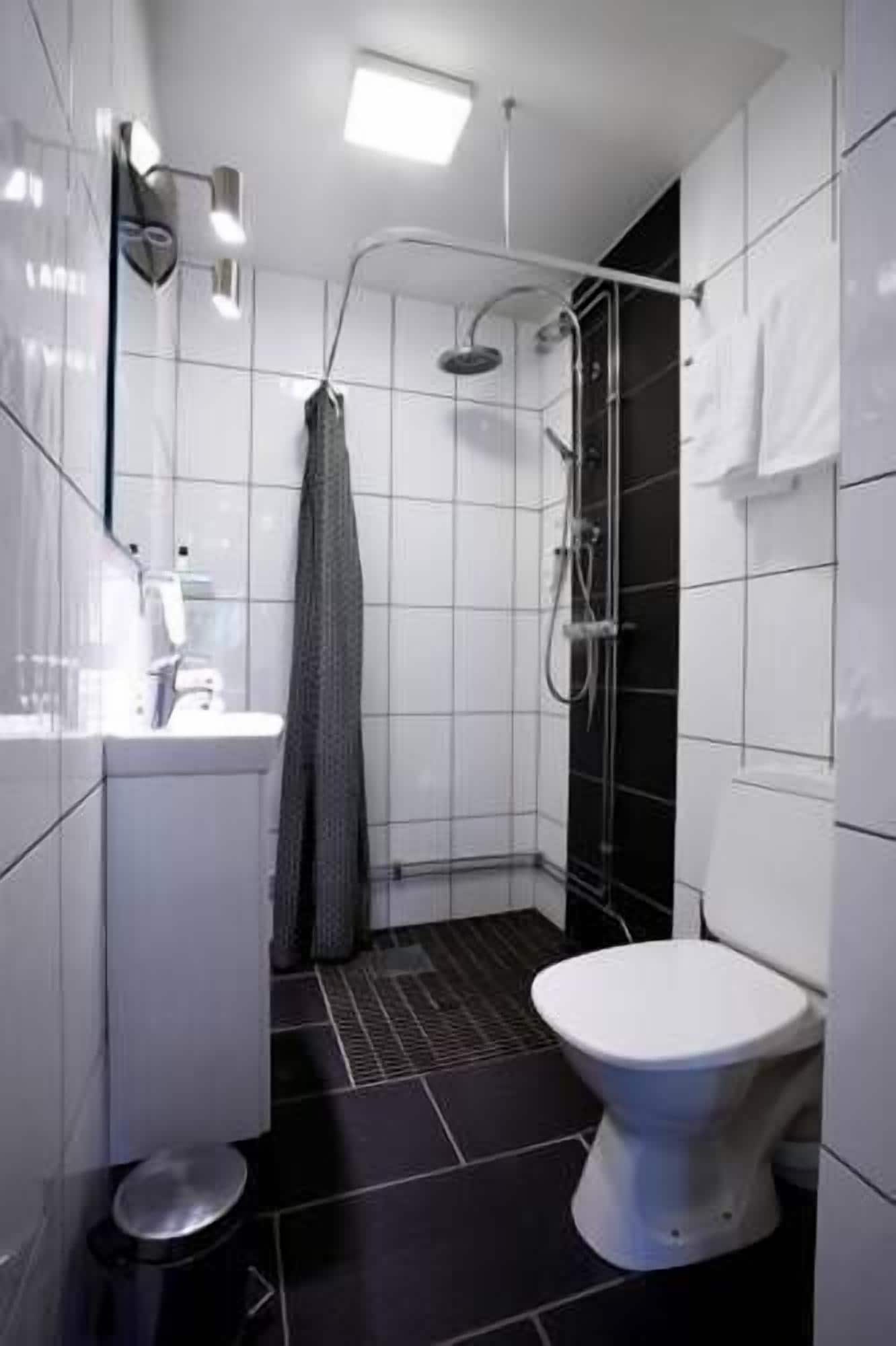 A modern bathroom with a shower, toilet, and sink.
