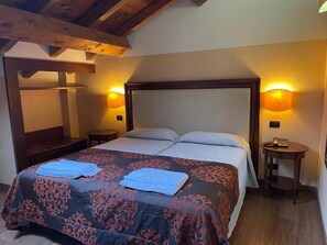 Un dormitorio con una cama grande, dos mesitas de noche y techo de madera.