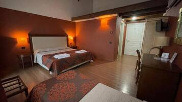 Une chambre d’hôtel avec deux lits, un bureau, une chaise et une porte.