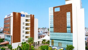 Un hôtel moderne, reconnaissable à son grand panneau « Golden Tulip », doté d’une terrasse sur le toit agrémentée de palmiers et offrant une vue sur le paysage urbain.