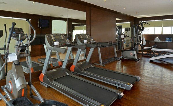 A gym with treadmills, elliptical machines, and weight equipment.