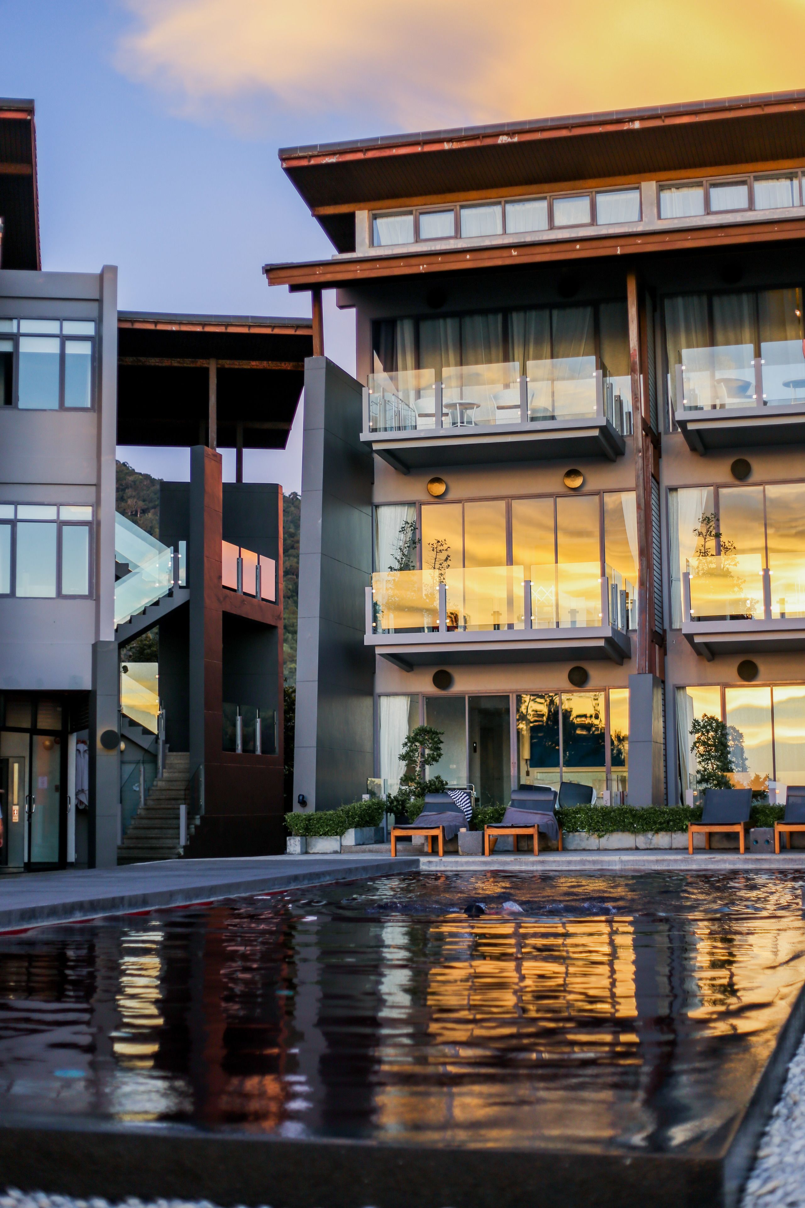 A modern building with multiple balconies and a swimming pool.