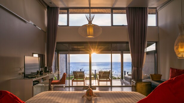 A bedroom with a large bed, a desk, a TV, and a view of the ocean. - The Houben - Adult Only (Ko Lanta)