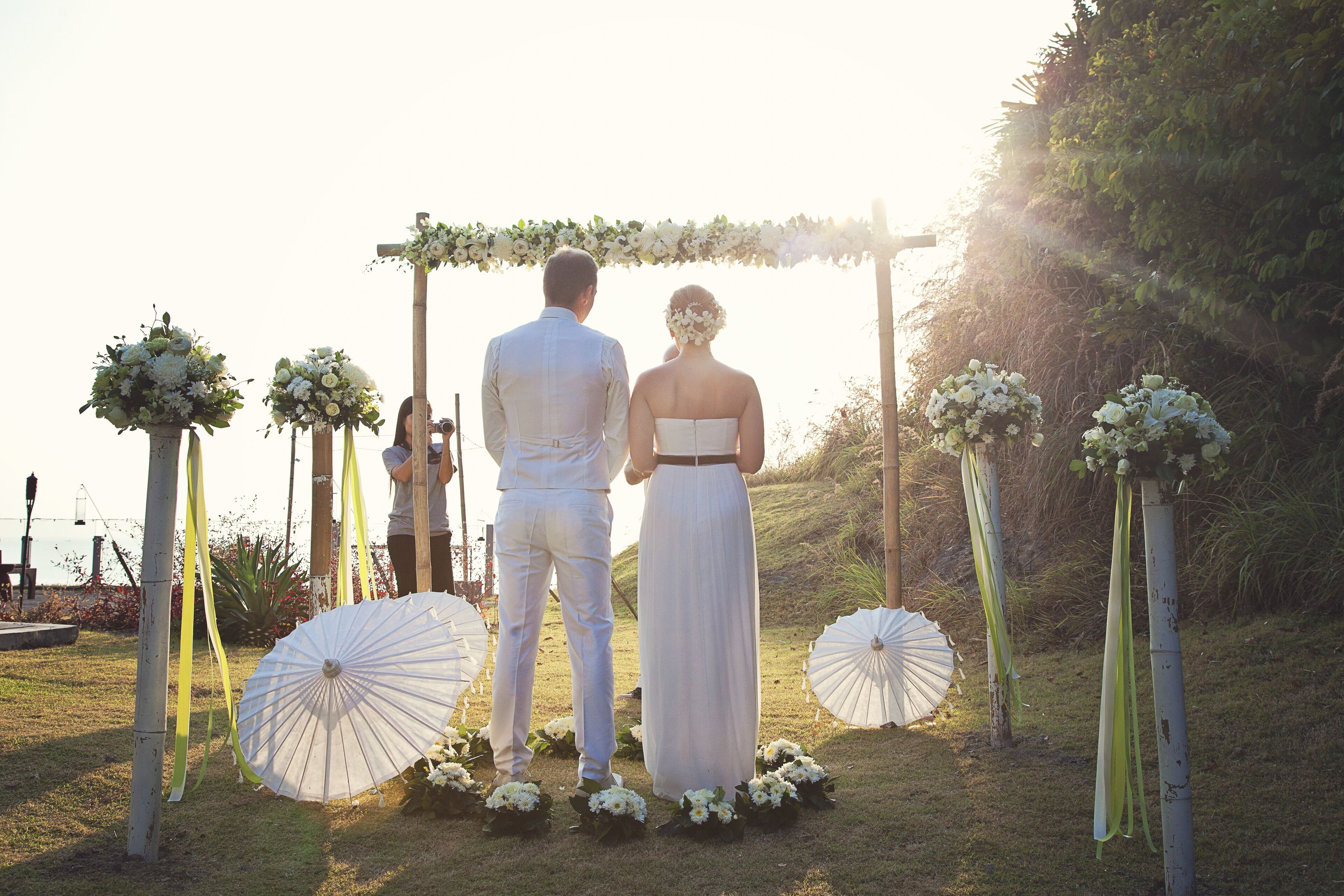 Una pareja bajo un arco floral en una ceremonia de boda.