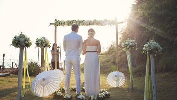 Una pareja bajo un arco floral en una ceremonia de boda.