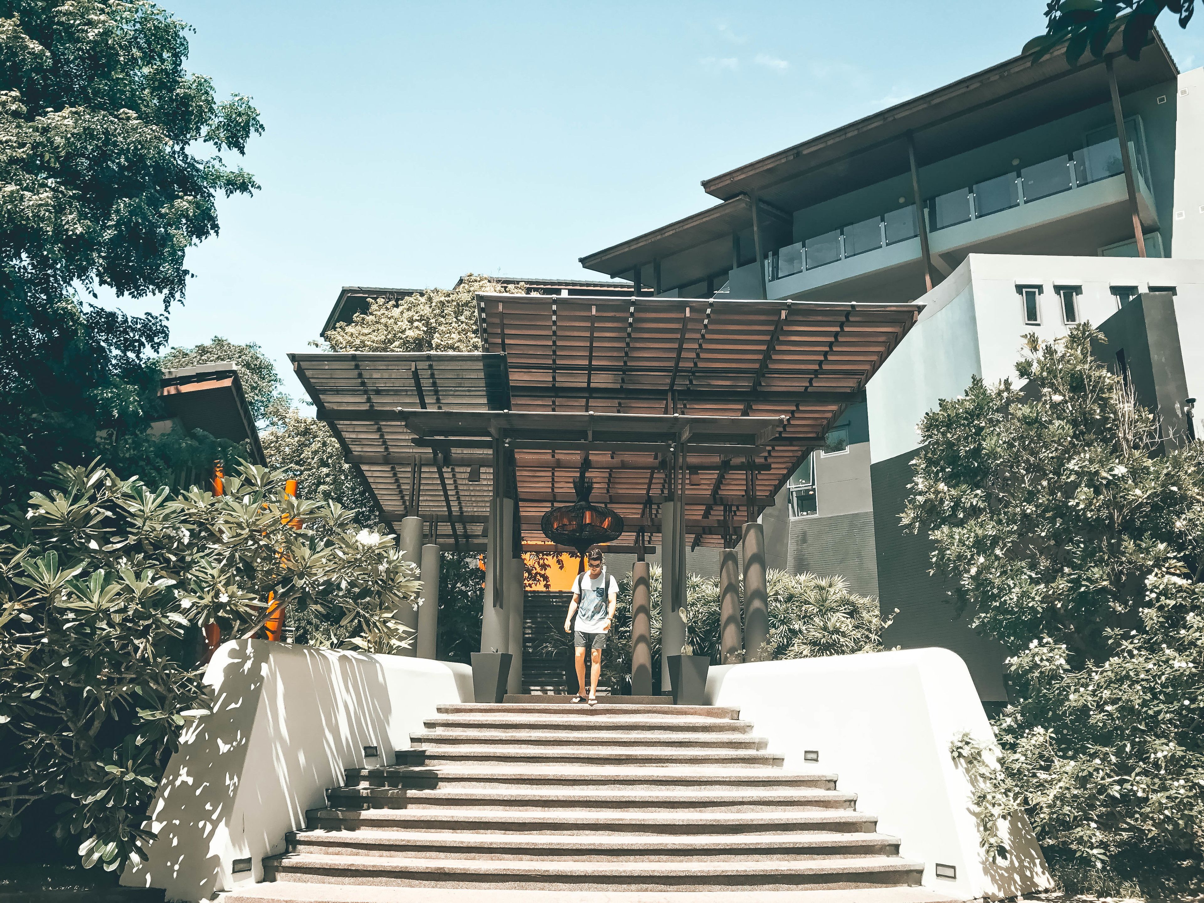 A modern building with a covered entrance and a staircase leading up to it.