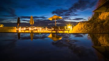 Alberca al aire libre, sombrillas en la alberca y camastros