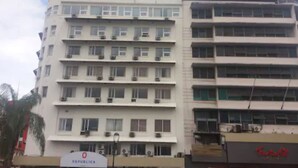 A multi-story building with a flat facade, multiple balconies, and a sign indicating it is a public building. - Hotel República (Panama City)