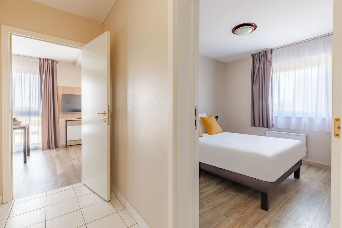 Une chambre d’hôtel avec un lit, un bureau et une télévision.
