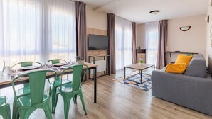 Una sala de estar moderna con sofá, mesa de comedor y sillas.