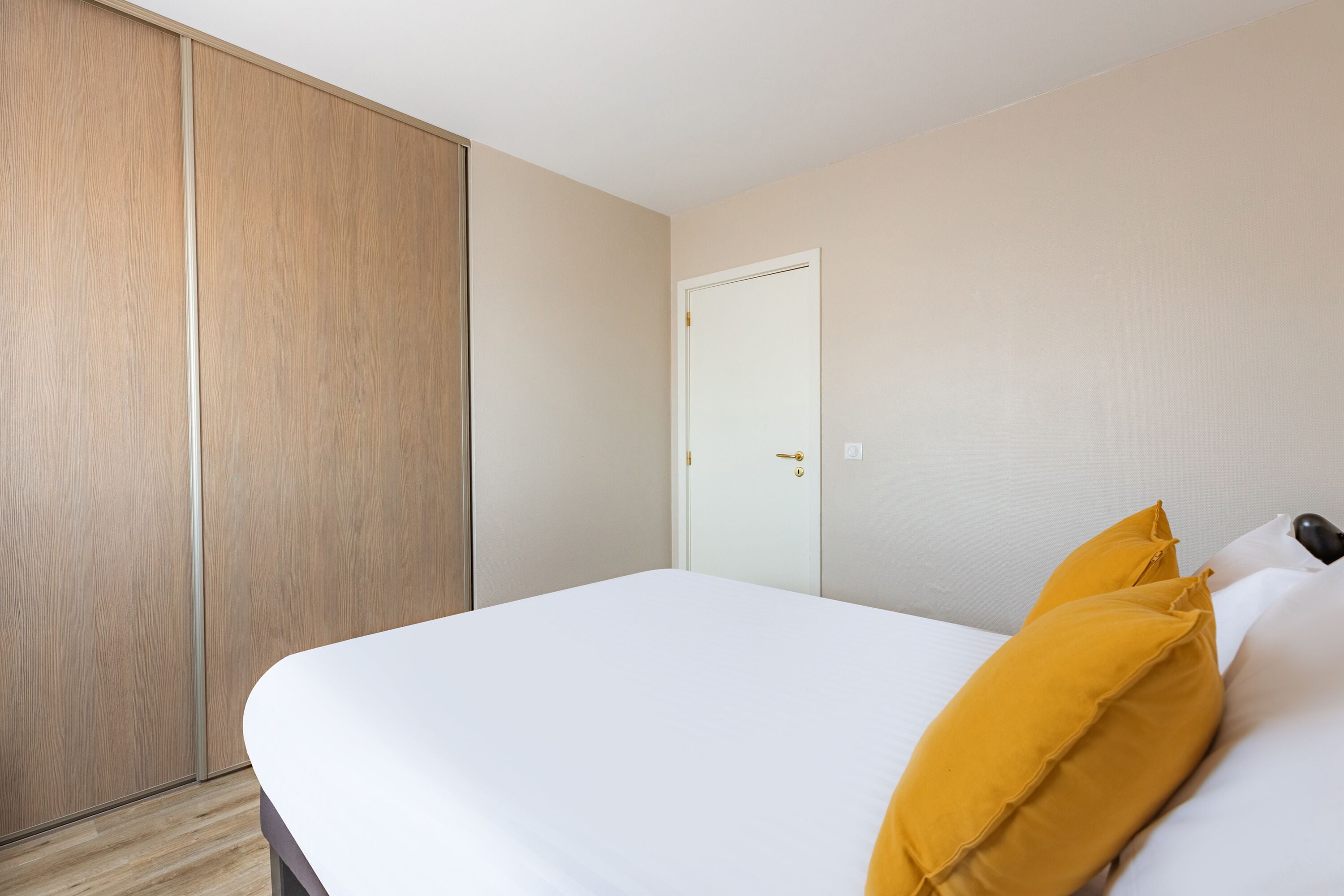 Une chambre à coucher avec un lit, une armoire et une porte.