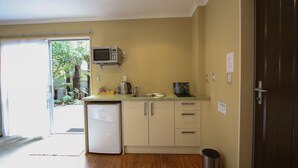 A compact kitchen with a microwave, sink, and a small refrigerator. - Annabelle Motel (Hokitika)