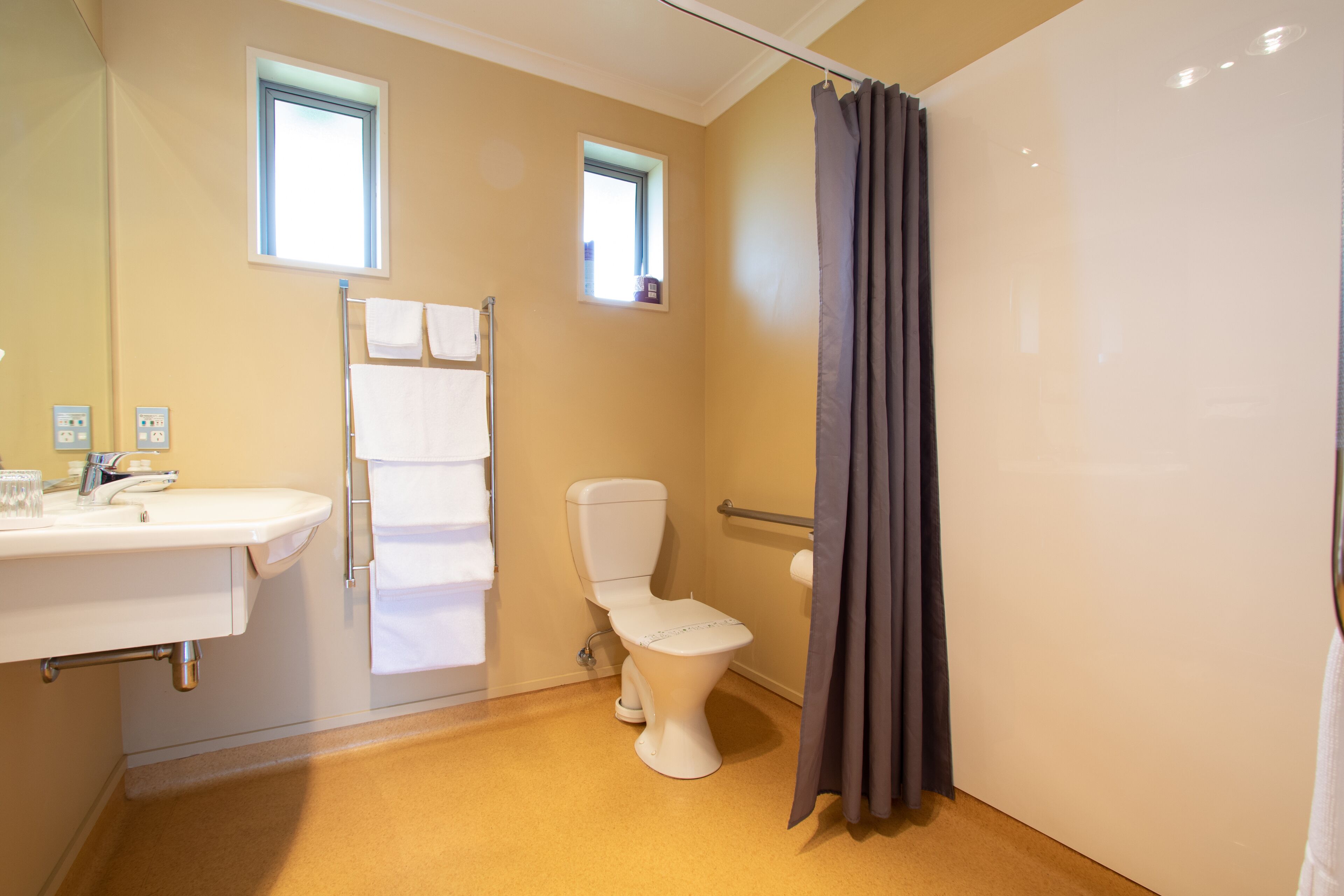 A bathroom with a toilet, sink, and shower curtain.