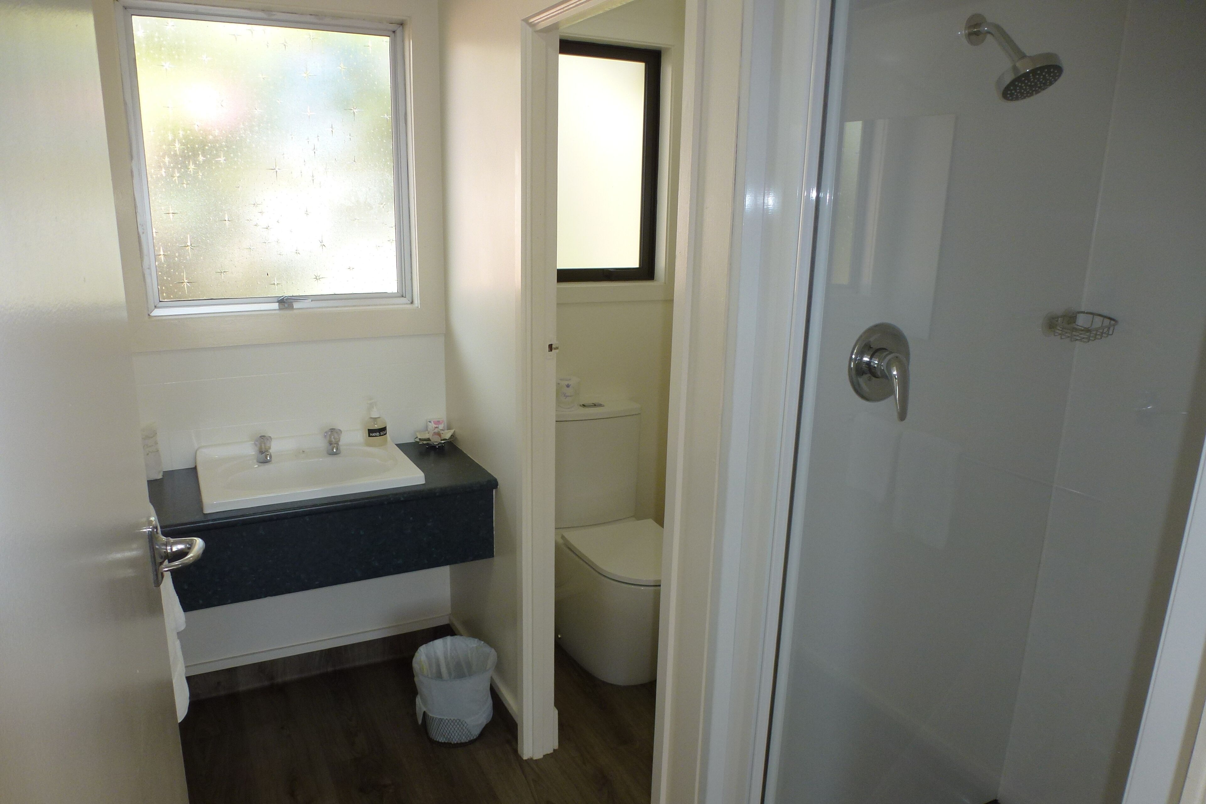 Un bagno con lavandino, water e doccia.
