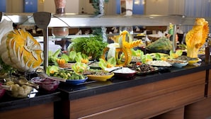 Buffet com diversos pratos e uma escultura decorativa de peixe.