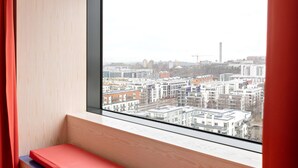 Una habitación con un ventanal que ofrece vistas a un paisaje urbano.
