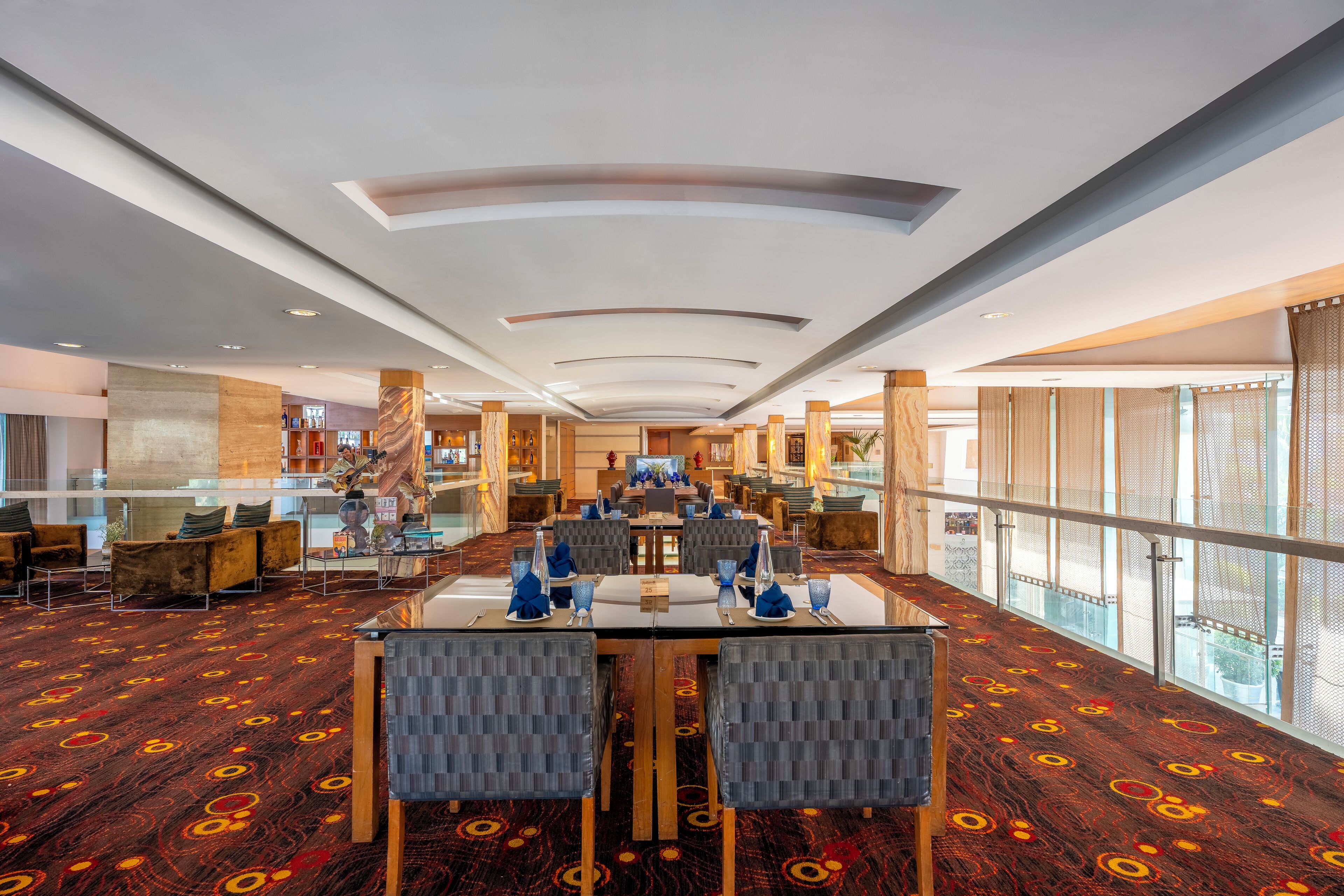 Un hall d’hôtel spacieux, doté d’un long comptoir d’accueil, de sièges confortables et de grandes fenêtres offrant une vue dégagée.