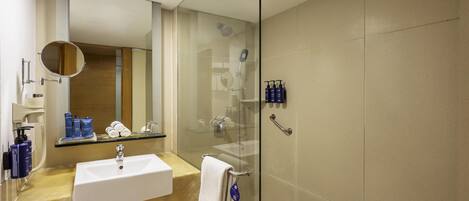 Une salle de bain moderne avec une douche à parois de verre, un lavabo blanc et un miroir.