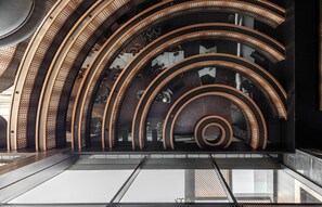 Un interior moderno con elementos arquitectónicos curvos y un suelo reflectante.