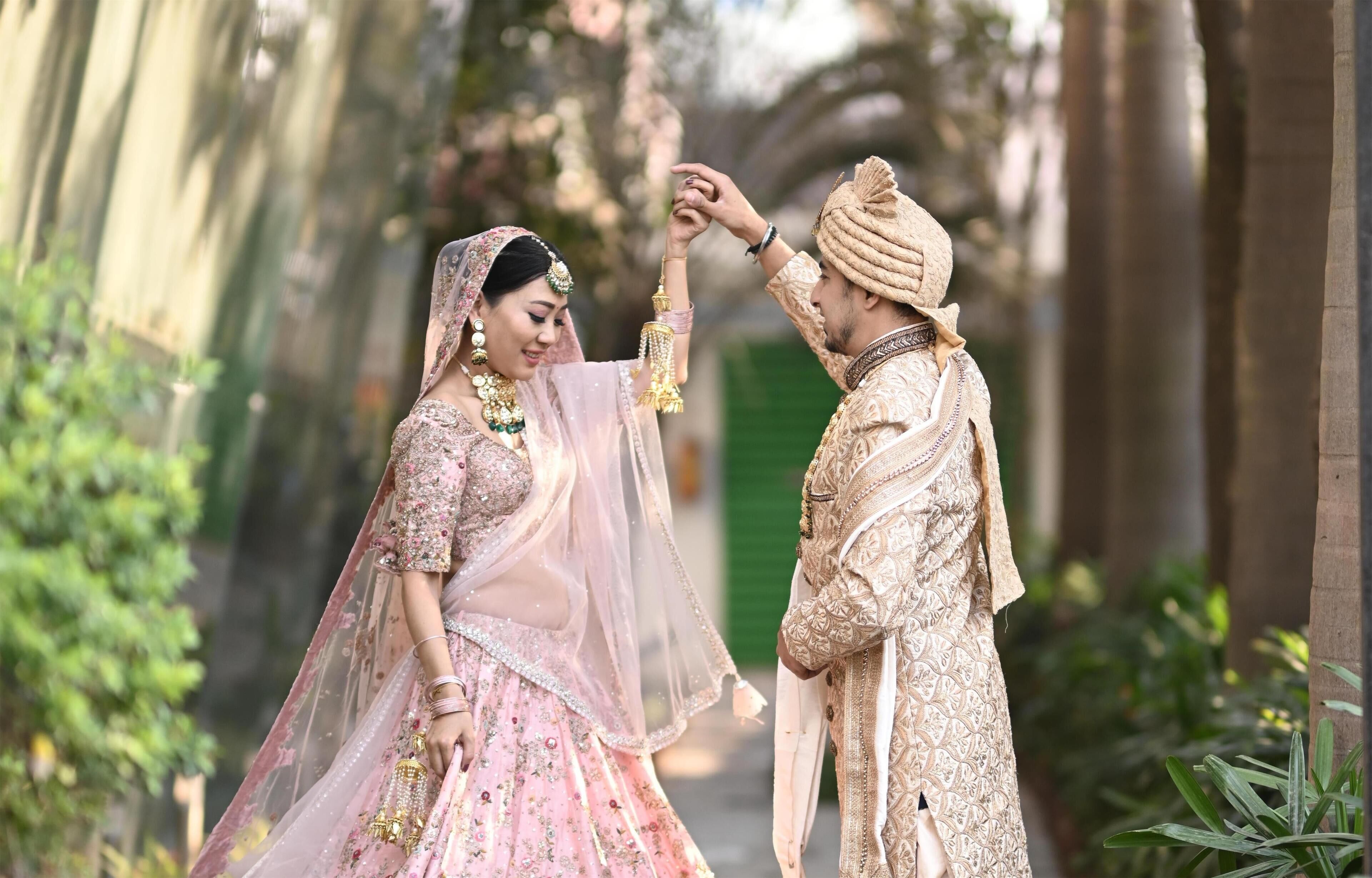 A couple in traditional wedding attire in an outdoor setting.