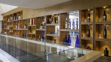 A modern bar with shelves of liquor bottles and glasses.
