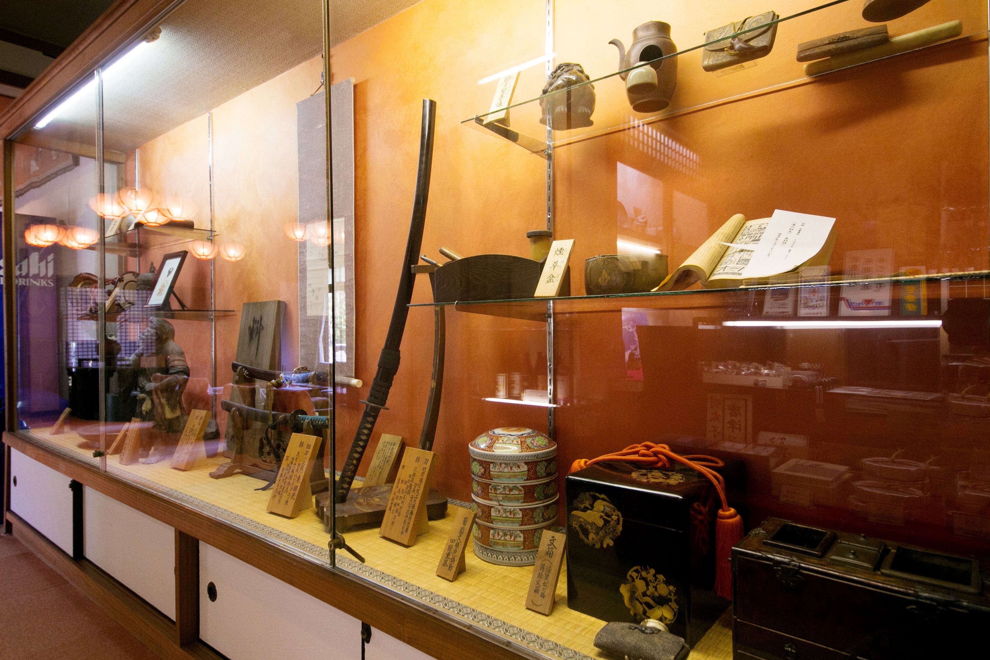 Una vitrina exhibe diversos artefactos históricos, como cerámica, pergaminos y herramientas tradicionales.
