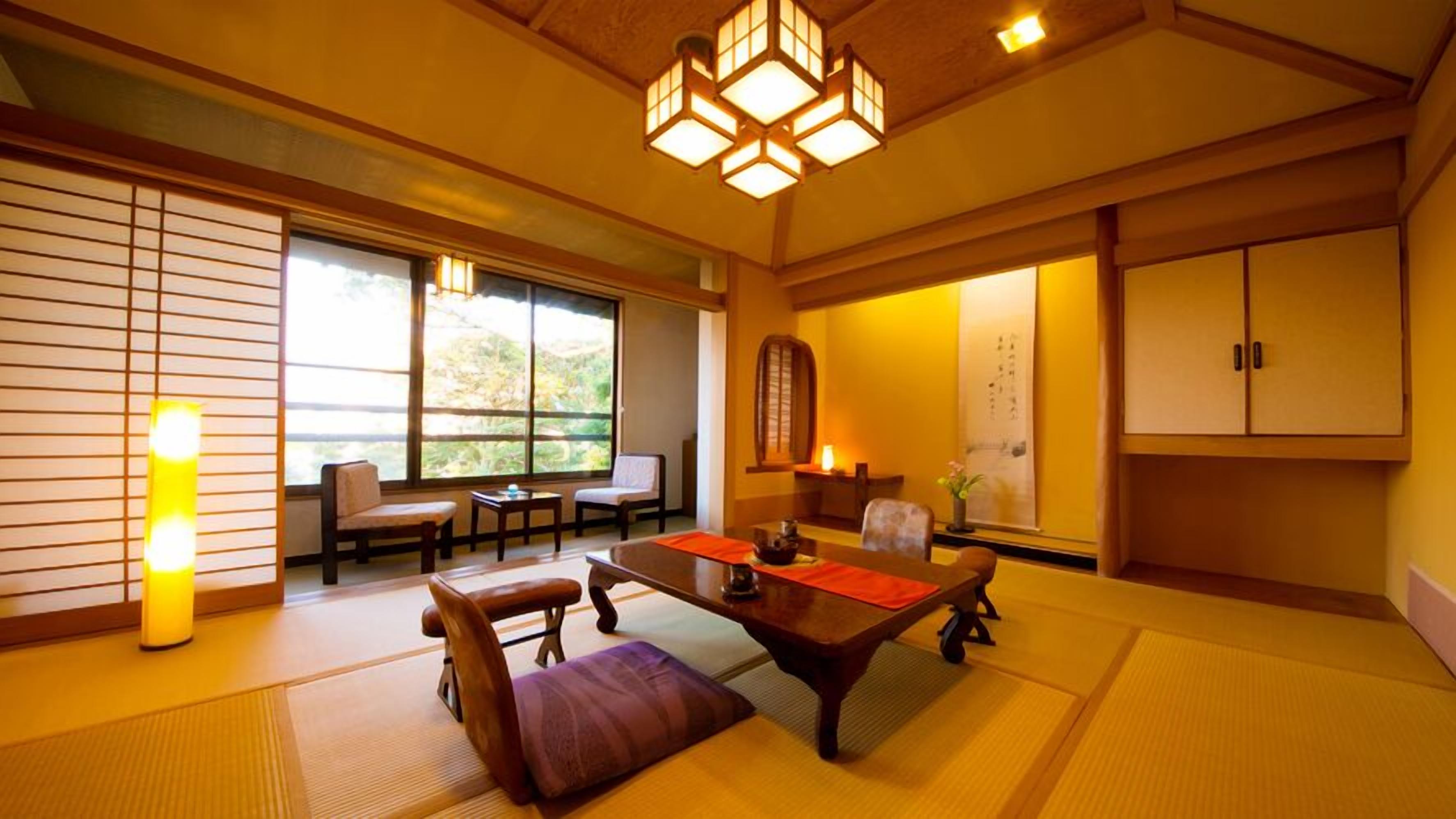 Una stanza tradizionale giapponese con pavimento in tatami, un tavolino con cuscini, porte scorrevoli e vista sul verde.