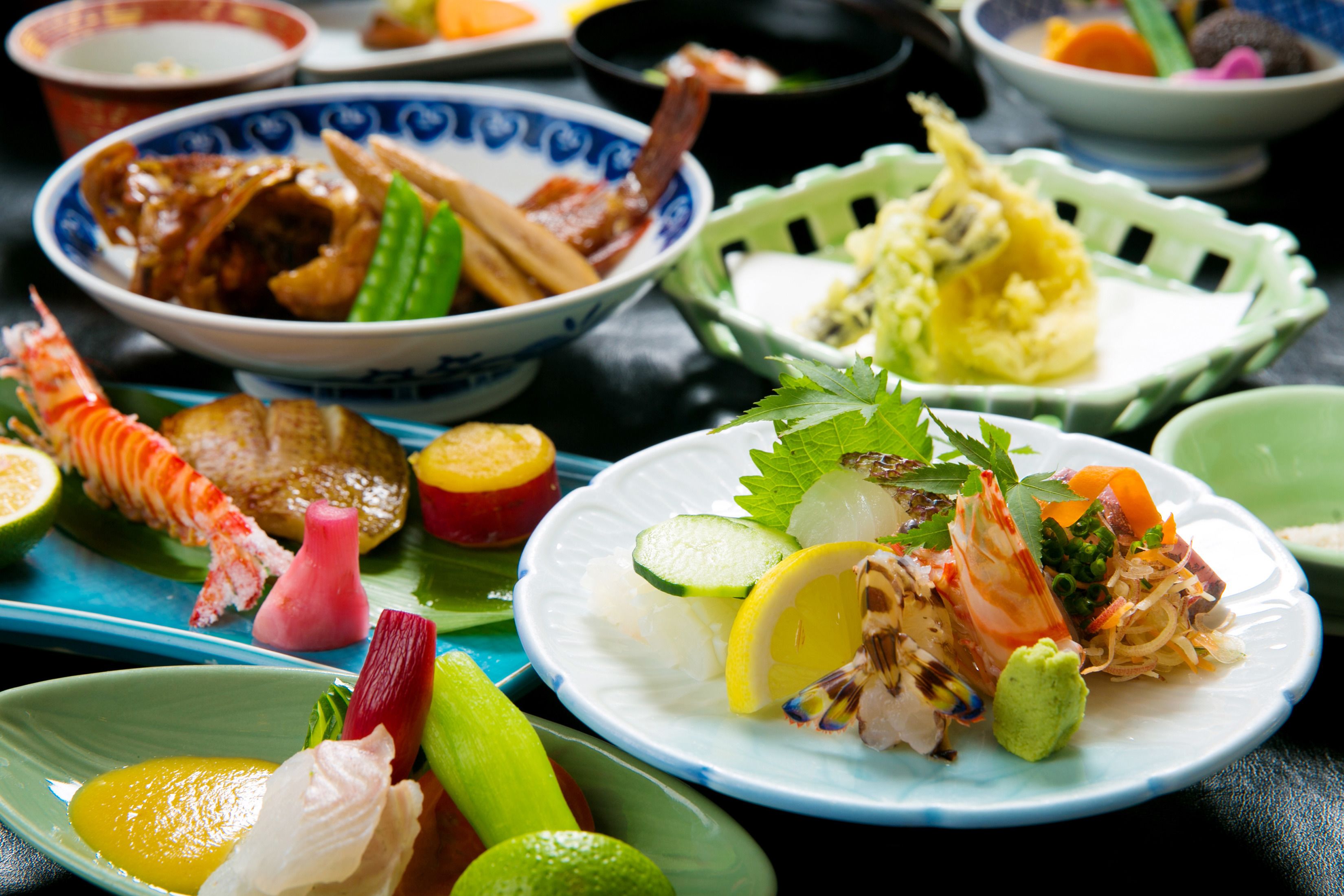 Una variedad de platos en una mesa, que incluyen mariscos, verduras y quizás comida asiática.