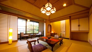 A traditional Japanese room with tatami flooring, a low table, and sliding doors. - Ryokan Wataya (Karatsu)