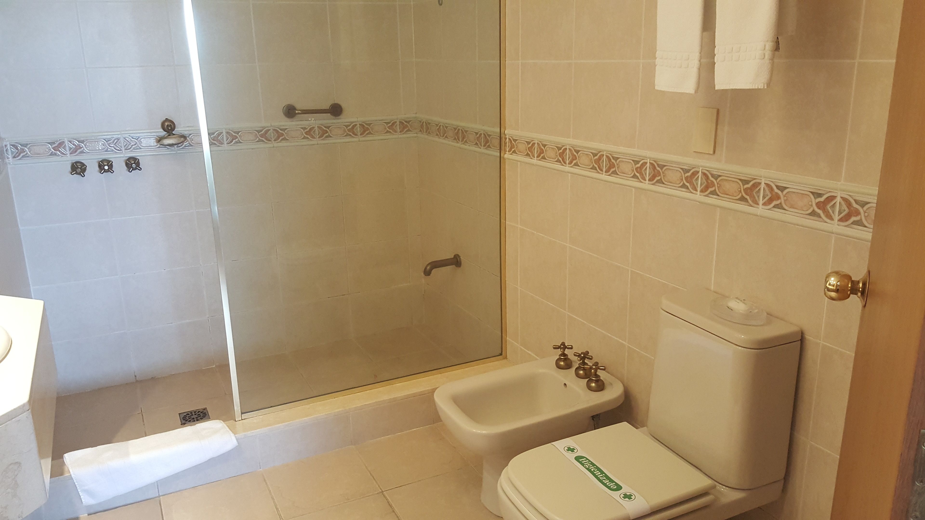Un baño con cabina de ducha de vidrio, inodoro y bidé.