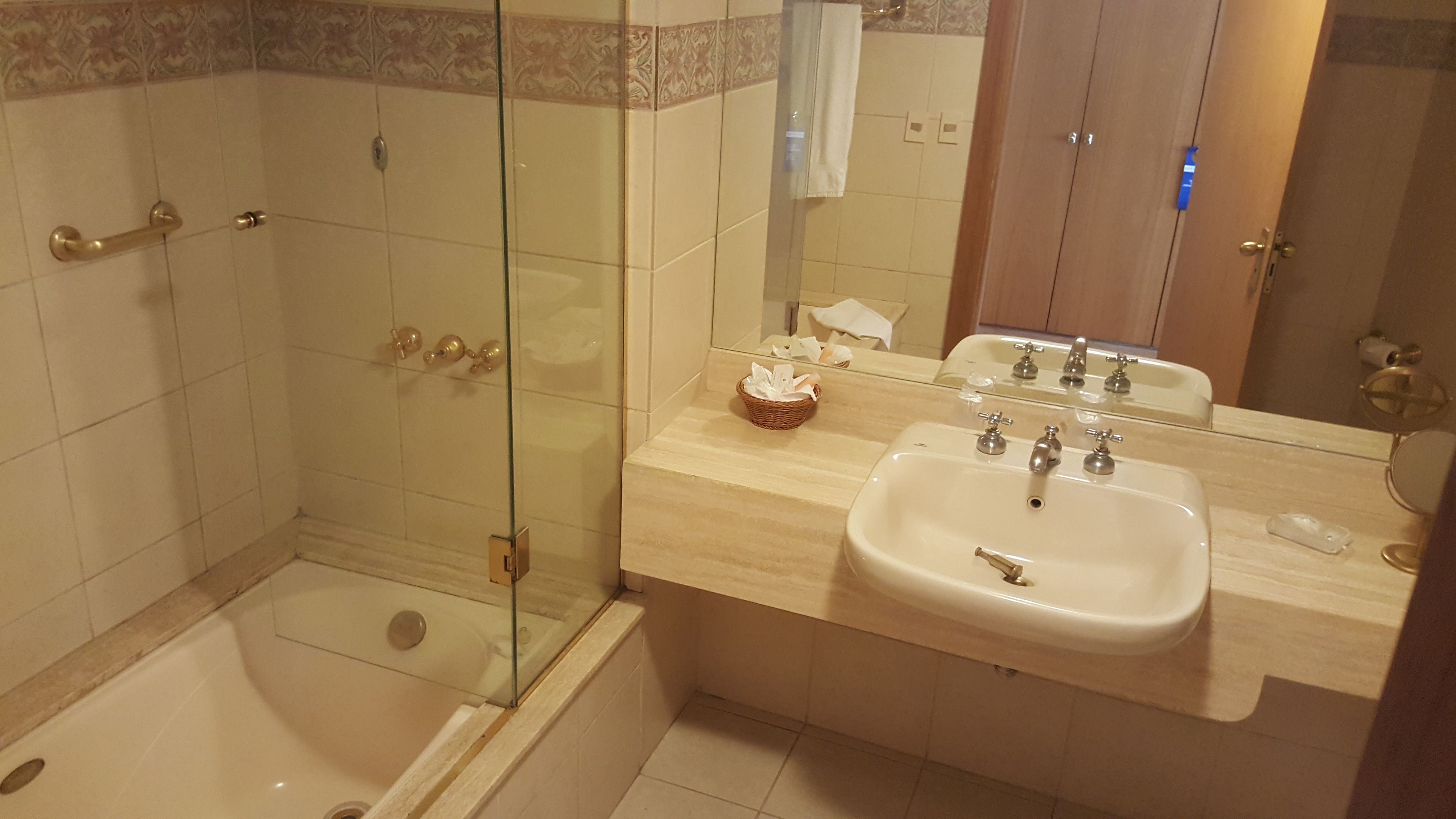 Ein Badezimmer mit Duschkabine, Badewanne, Waschbecken mit Spiegel und Handtuchhalter.