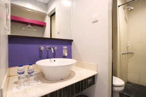 A bathroom with a white sink, purple wall, and a shower area. - Grand Lifestyle Hotel (Denpasar)