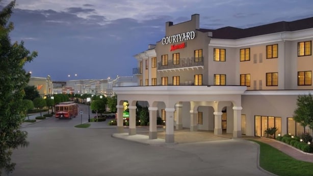 A Courtyard Marriott hotel with a large entrance, multiple balconies, and a well-lit facade. - Courtyard by Marriott Shreveport-Bossier/Louisiana Boardwalk (Bossier City)