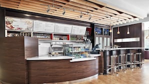 A modern bistro with a wooden ceiling, a counter with a coffee machine, and a menu board. - Courtyard by Marriott Shreveport-Bossier/Louisiana Boardwalk (Bossier City)